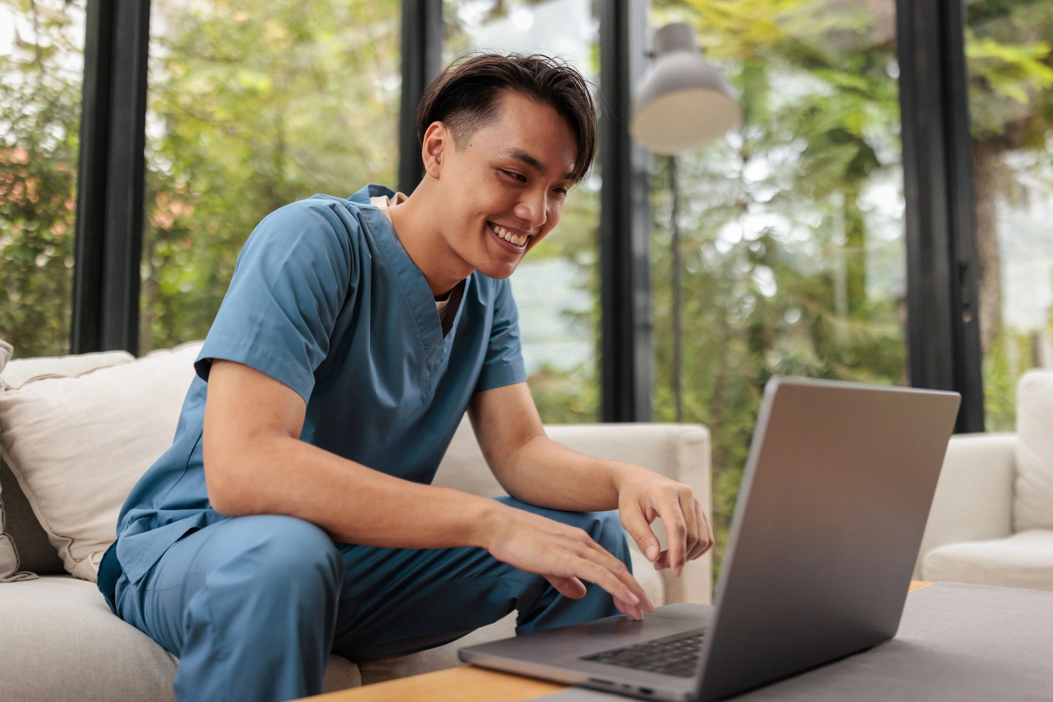 Person using a laptop at home while reviewing information