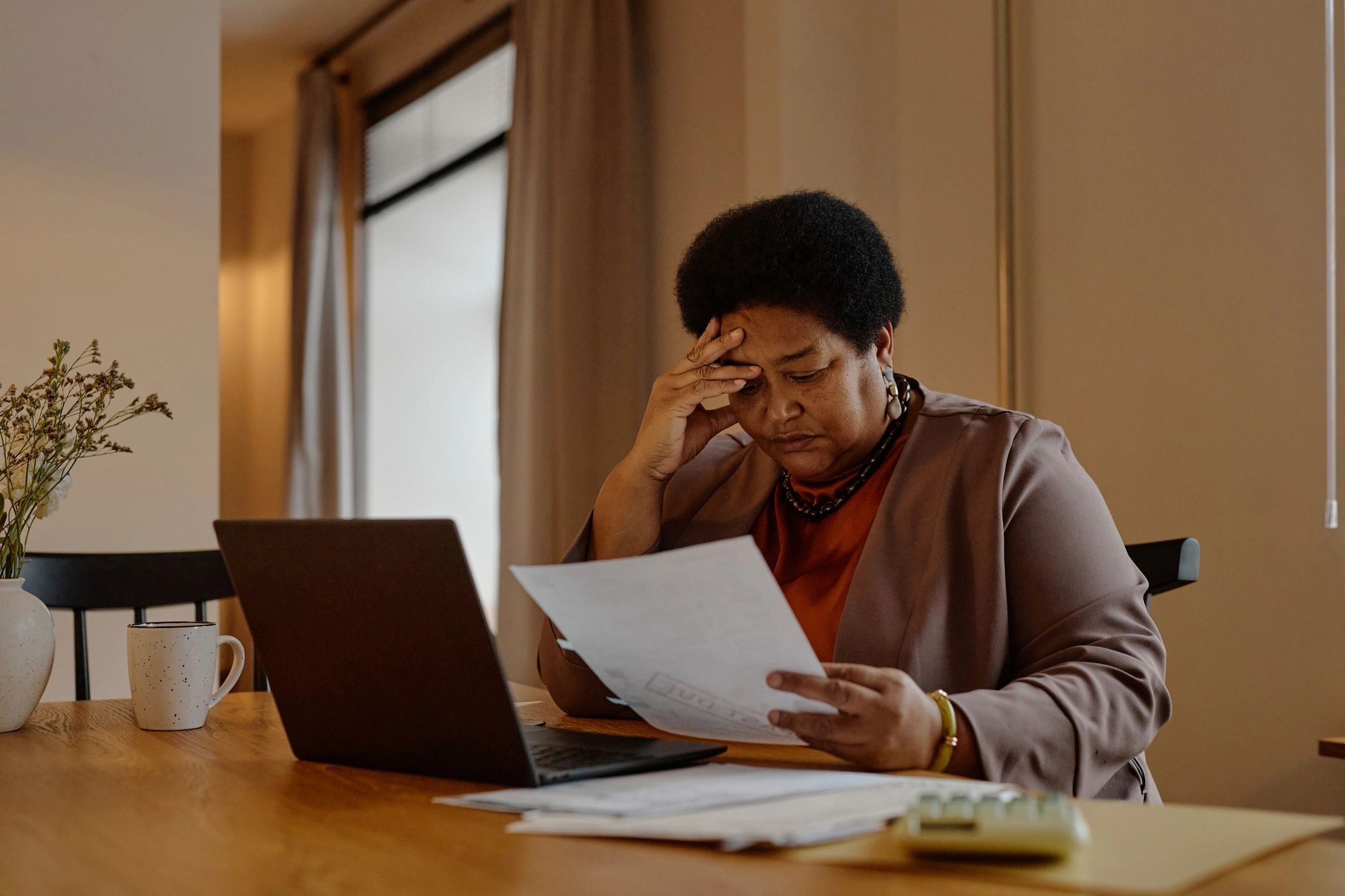 Person reviewing utility-related paperwork and a laptop at home